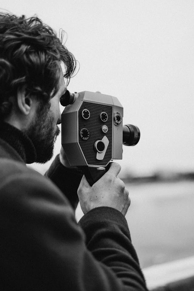 Boy with film camera shoots into the distance